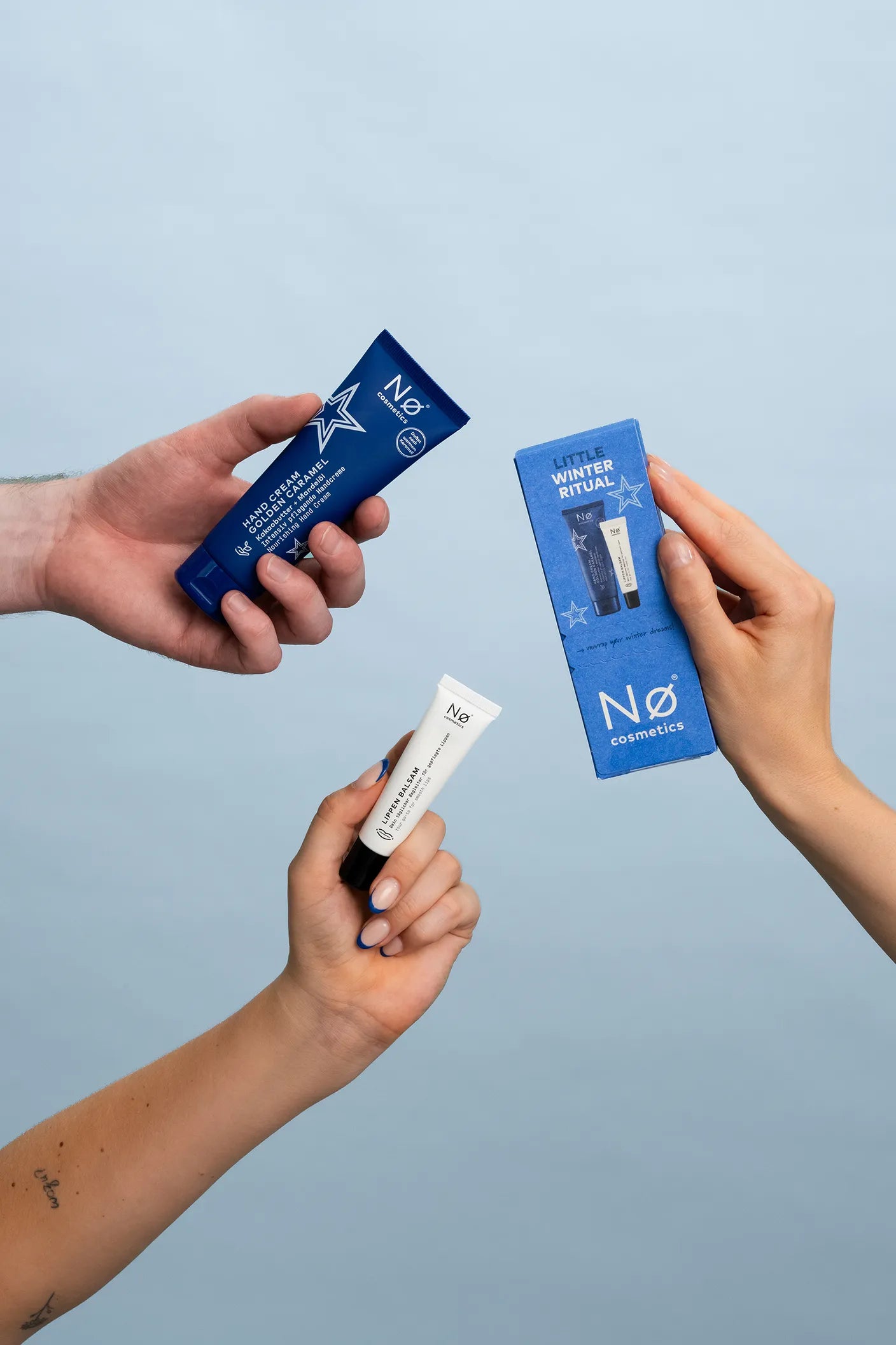 Drei Hände halten drei Winter-Edition-Produkte von Nø Cosmetics 2026.