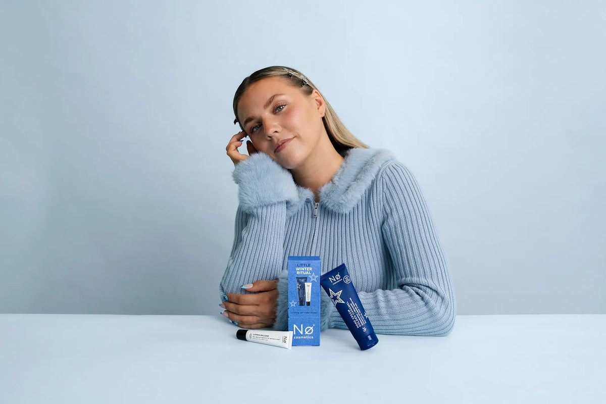 Frau sitzt am Tisch vor dem Nø Cosmetics Little Winter Ritual Geschenkset aus 2026.