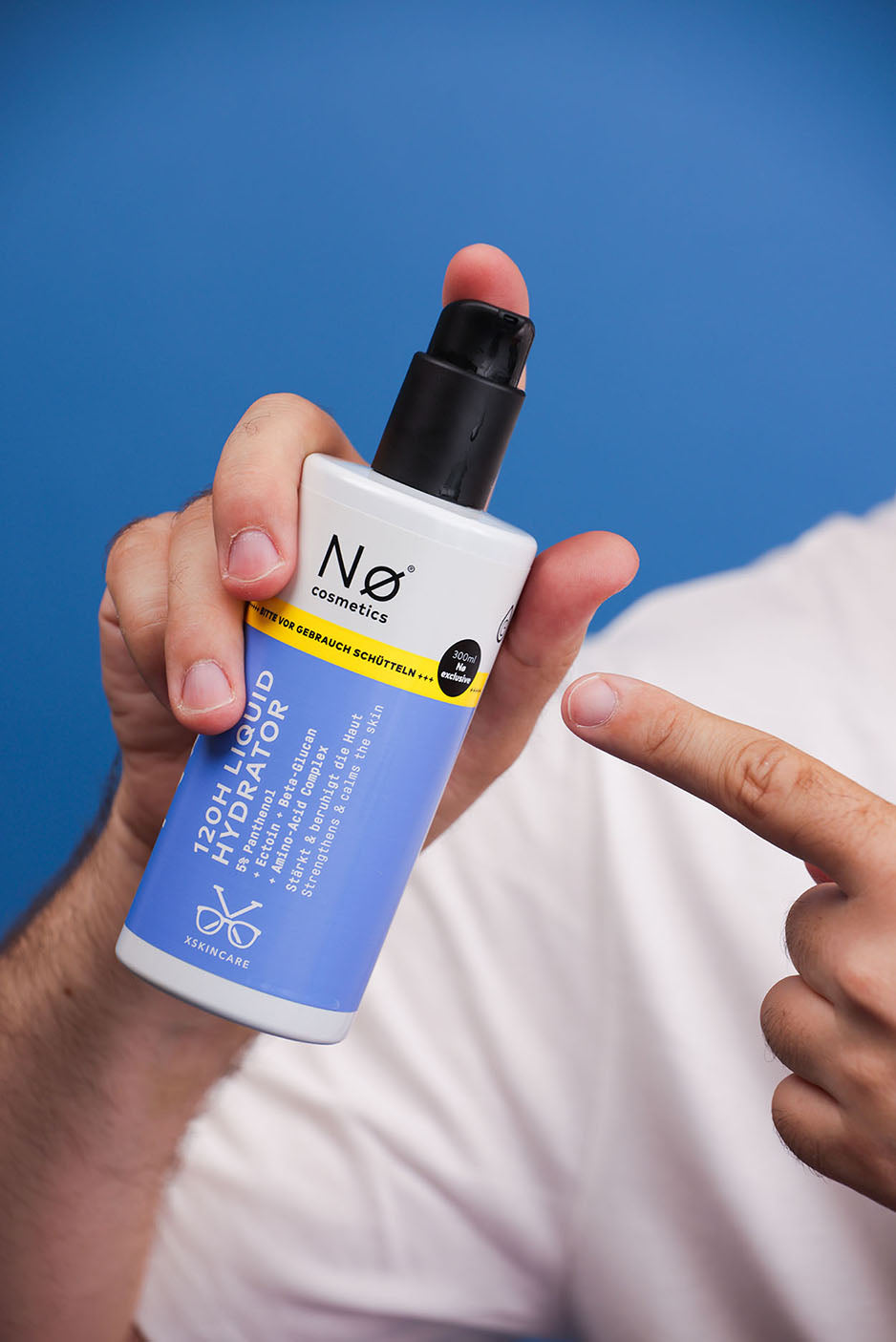 Person hält XL Liquid Hydrator in der Hand auf blauem Hintergrund.