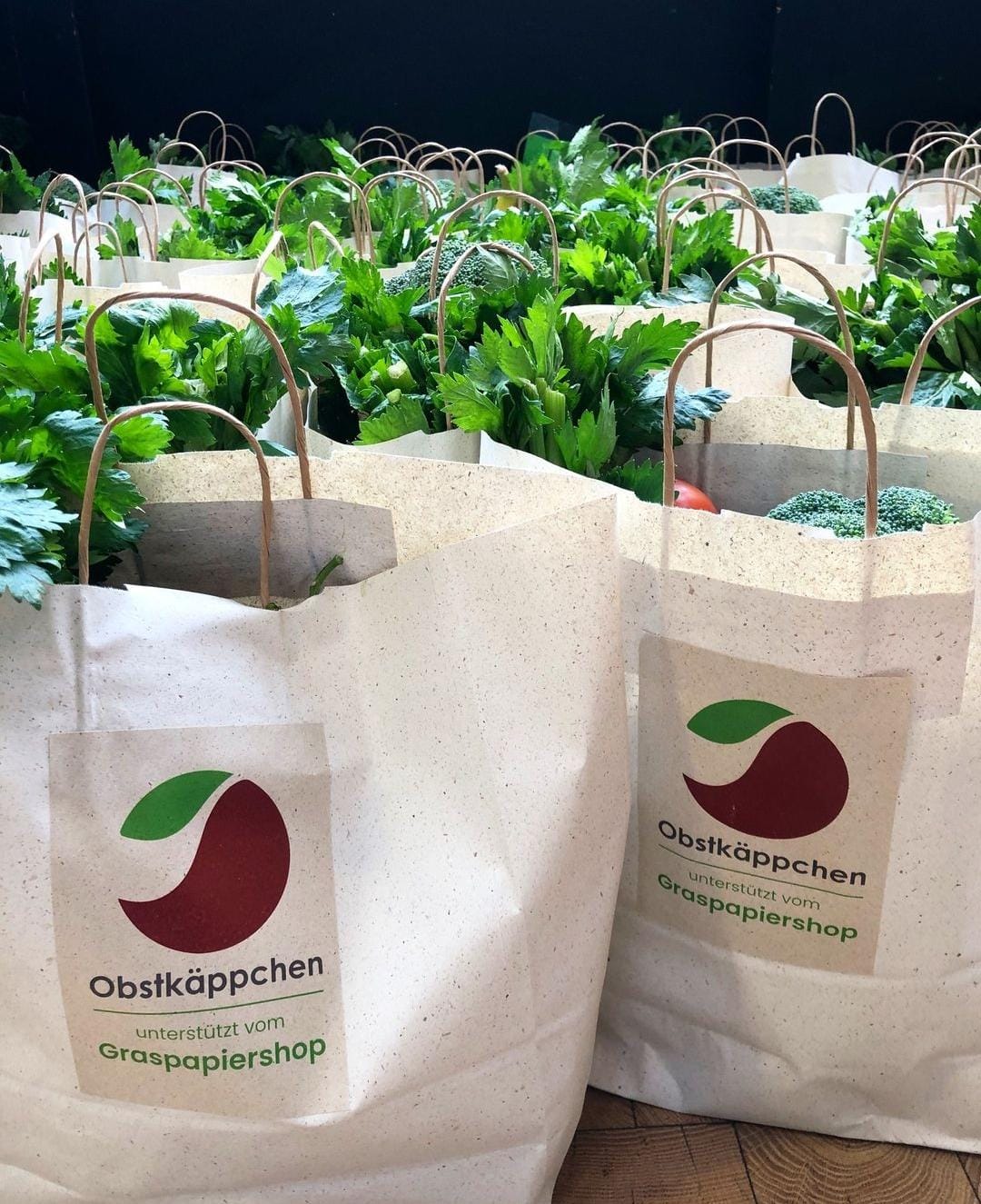 Die Tüten von Obstkäppchen sind mit gesunden Lebensmitteln, wie Gemüse, befüllt.
