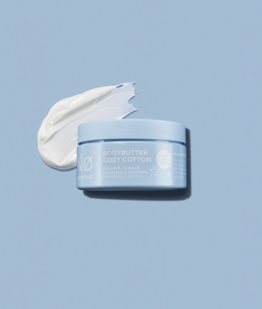 Produktbild der Body Butter Cozy Cotton von Nø Cosmetics auf blauem Hintergrund.