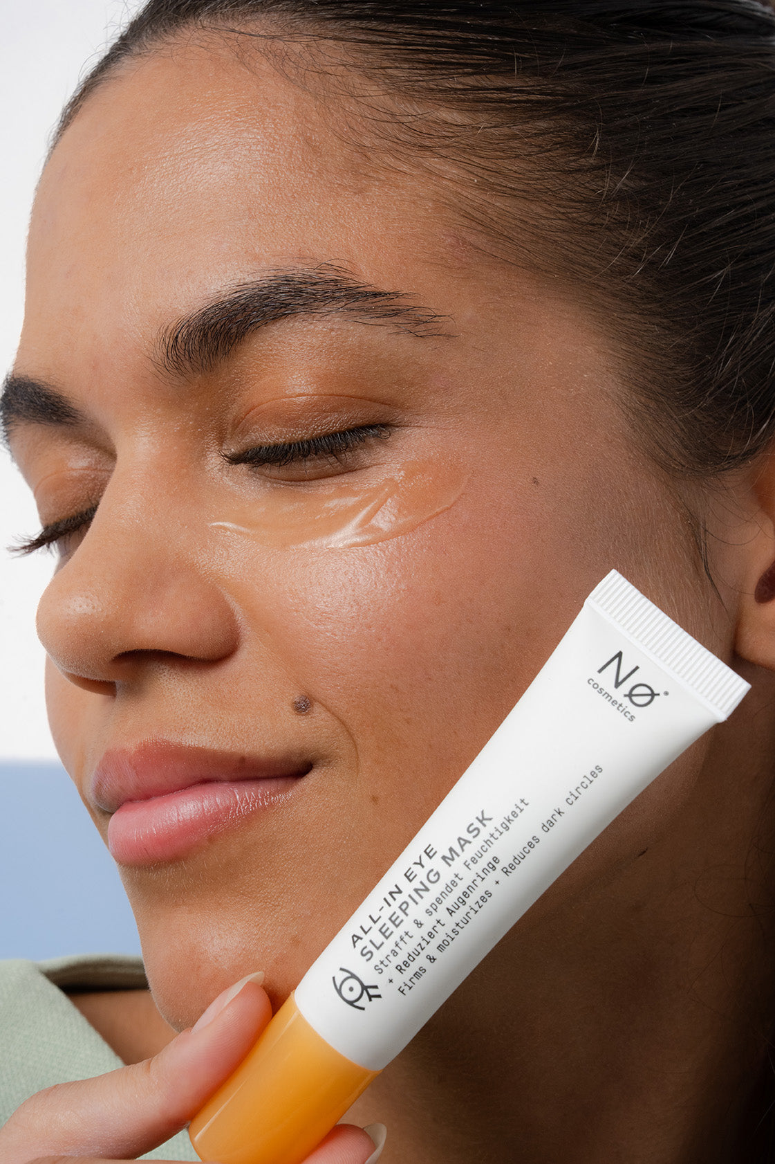 Eine Person hält die ALL-In Eye Sleeping Mask von Nø Cosmetics nah an ihr Gesicht. Auf ihrer Augenpartie sieht man die Textur der Eye Sleeping Mask.