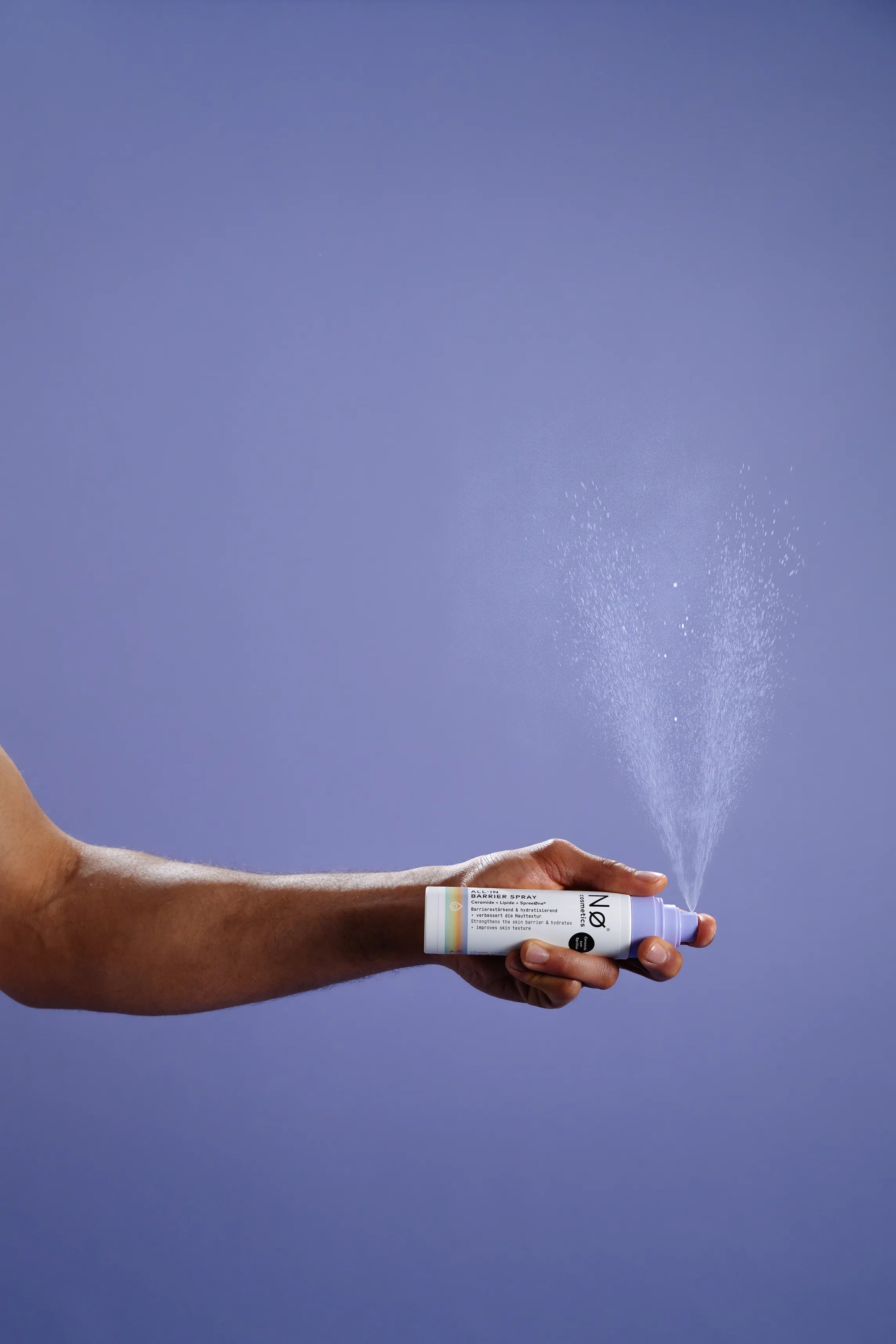 Eine Person sprüht das ALL-IN Barrier Spray von Nø Cosmetics
